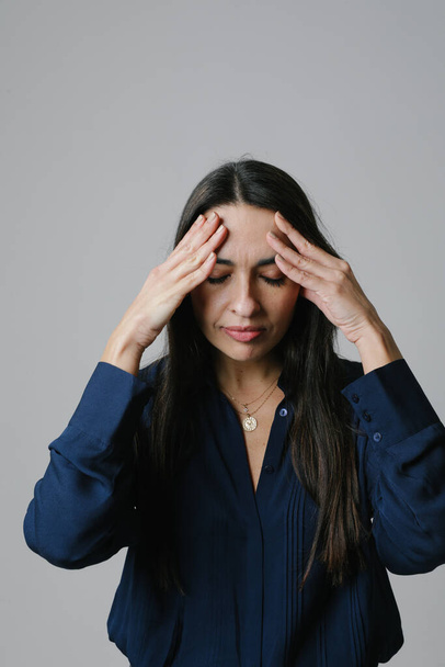 Vertical portrait of a stressed middle-aged woman posing on white background. High quality photo - Zdjęcie, obraz