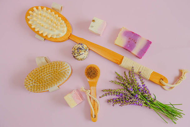 Lavendelzeep. lavendelextract.Lavendel badzeep en truffels en natuurlijke borstels en lavendelbloemen op een roze achtergrond. Aromatherapie en spa  - Foto, afbeelding