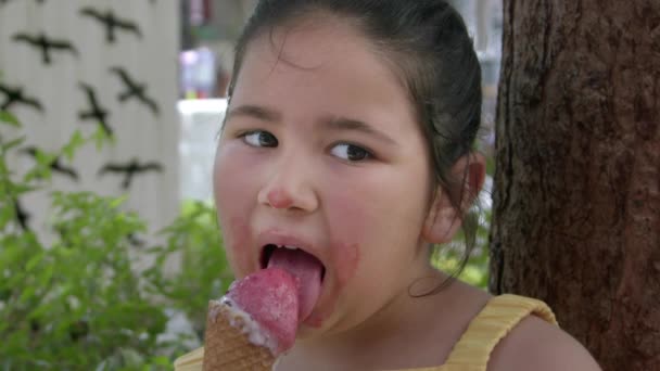 Klein meisje op zoek naar camera terwijl het eten van ijs Beelden. - Video