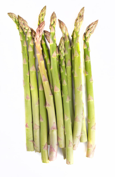 Asparagus on a white background, vertical view. Green seasonal vegetables, isolated. Packshot photo for package design, template. - Φωτογραφία, εικόνα