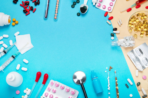 Various medical equipment, ampoules, pipette, drugs, tablets, capsules, spray on blue background. Top view. - 写真・画像