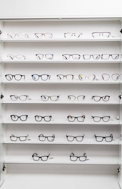 Optical accessories store. Stand of eyeglasses in shop. - Foto, Bild