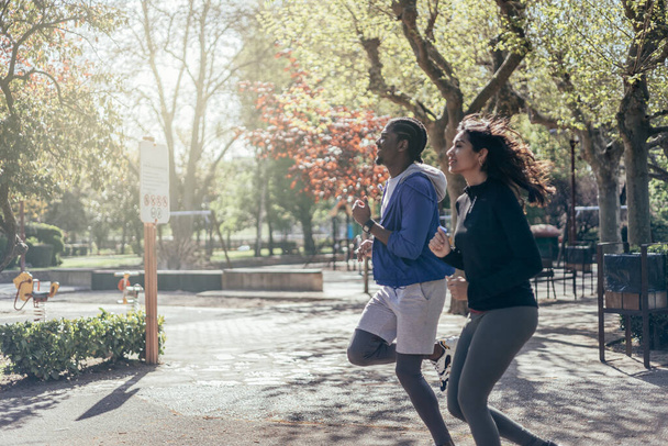 monietninen juoksija pari lenkkeily puistossa - Valokuva, kuva