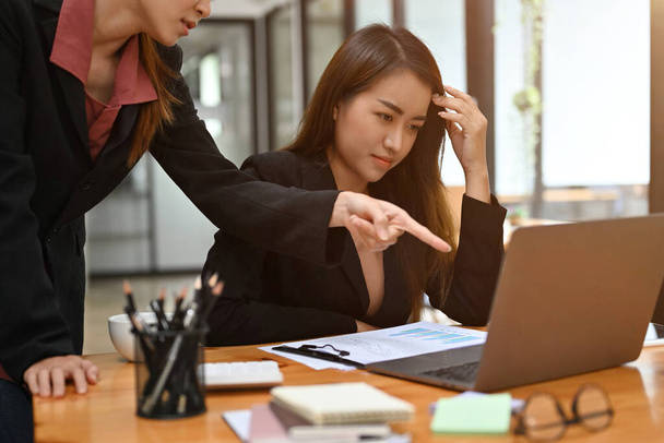 Uma jovem funcionária asiática estressada recebe feedback ruim sobre seu projeto de trabalho e desempenho de seu gerente. - Foto, Imagem