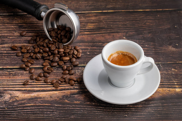 Φρέσκος καφές espresso μαζί διακοσμημένος με κόκκους καφέ στο ξύλινο τραπέζι - Φωτογραφία, εικόνα