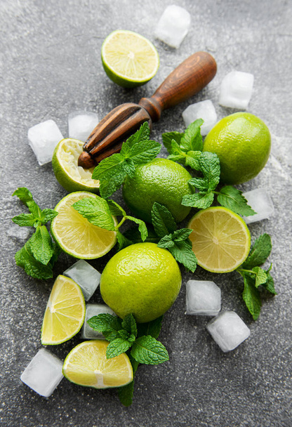 Lime, mint and ice on a dark background. The ingredients for making refreshing drinks and cocktails. - Valokuva, kuva