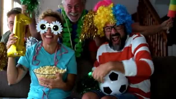 Coole Familie in lustigen Kostümen schaut Fußballspiel und Begleitteam zu - Filmmaterial, Video