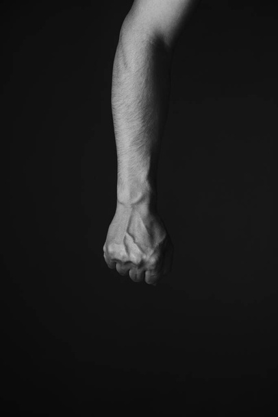 Brutal mans hand with protruding veins, black background.Black and white photo - Фото, изображение