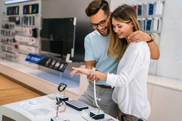 Technology people smart devices concept. Happy young couple buying new smart watch in tech store. - Foto, Imagen