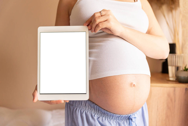 Schwangerschaft digitale Tablet-Attrappe. Schwangere mit Smart-Tablet. Mobile Schwangerschafts-Online-Bewerbungen täuschen vor. Konzept der Schwangerschaft, Mutterschaft, Erwartung der Geburt - Foto, Bild