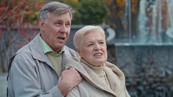 Ευτυχισμένοι ηλικιωμένοι παντρεμένοι συνταξιούχοι παππούδες περπατούν στο πάρκο του φθινοπώρου απολαμβάνουν συζήτηση μιλάμε σε εξωτερικούς χώρους καυκάσιος οικογένεια περνούν ελεύθερο χρόνο μαζί ανώτερος σύζυγος αγκαλιά ώριμη γυναίκα ρομαντικές σχέσεις - Πλάνα, βίντεο
