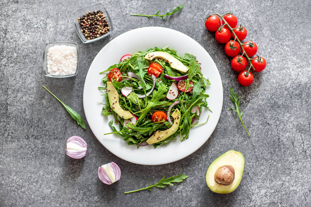 frischer Salat mit Rucola, Tomaten, Avocado und Rettich, gesunde Kost. - Foto, Bild