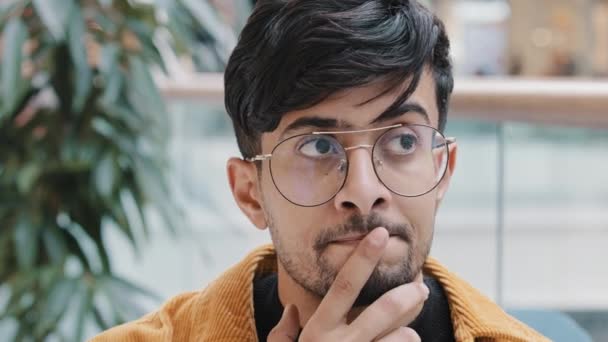 Férfi portré elmélkedő fiatal, magabiztos indiai férfi elmerül a gondolatokban emlékszik a megoldás keresésére tervez gondolkodás probléma jön az ötlet megtalálja a választ emel mutatóujj - Felvétel, videó