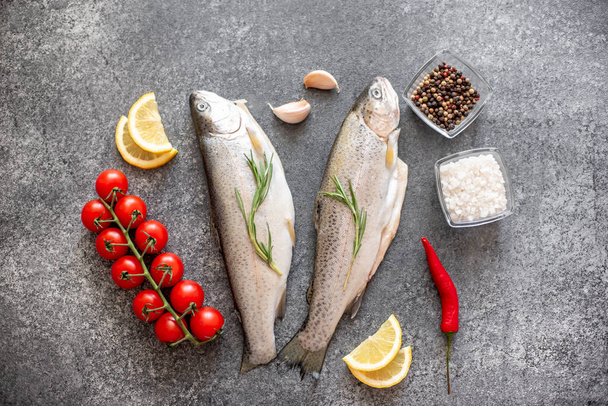 raw trout fish with ingredients on dark background - Foto, Imagen