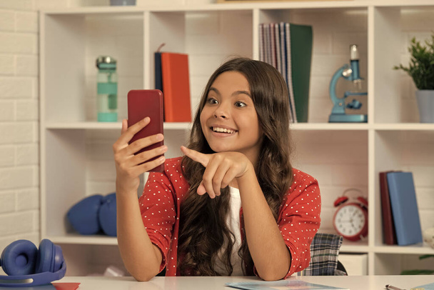 κατάπληκτος έφηβος κορίτσι κάνει βίντεο δείχνοντας δάχτυλο σε selfie χρησιμοποιώντας το κινητό τηλέφωνο, δημιουργός περιεχομένου. - Φωτογραφία, εικόνα