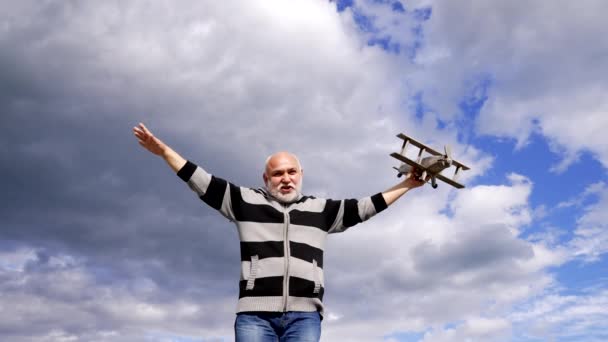 Щасливий бородатий чоловік уявляє, що летить на іграшковому літаку в небі, політ уяви
. - Кадри, відео