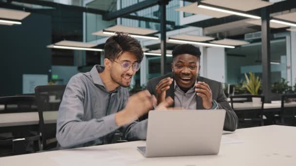 Boldog férfi partnerek változatos üzletemberek arab afrikai kollégák nézni laptop öröm jó hír kereskedelmi ajánlat izgatott Y-generációs férfiak ad öt győzelem online lottó érzés diadal kezet - Felvétel, videó