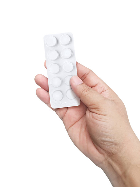 Hand holding medical drugs on white background. Pharmacy and medicine concept - Photo, image