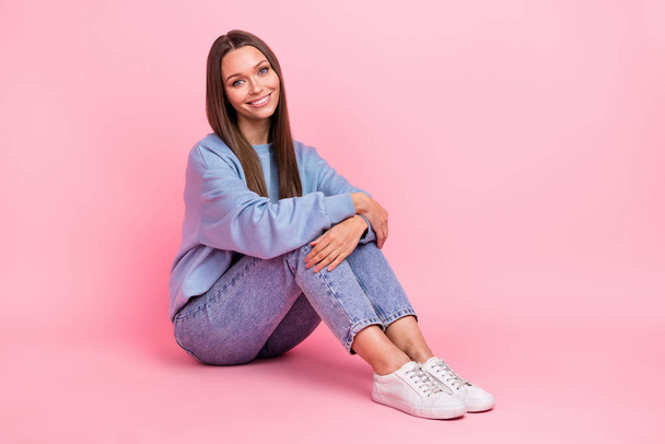 Portrait of attractive cheerful sweet brown-haired girl sitting on floor resting isolated over pink pastel color background. - Foto, afbeelding