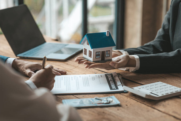 Real estate agents are carrying a housing model of the project to be forwarded to customers as home delivery. Real estate trading ideas and bank loans for buying and selling houses and land. - 写真・画像