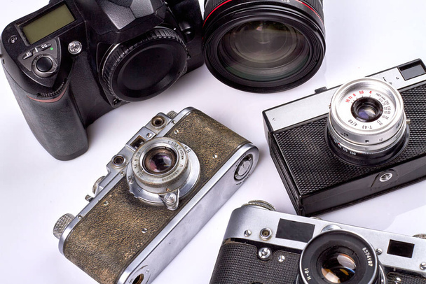 Close-up old-fashioned vintage photo cameras on white background. Collection of photography devices. - Photo, Image