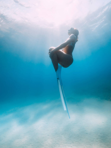 Жінка вільна від бікіні, позуючи над піщаним дном з білими плавцями. Приваблива жінка вільний дайвер у блакитному океані
 - Фото, зображення