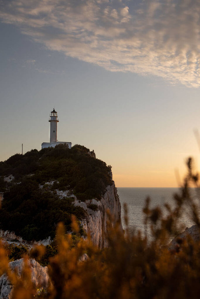 ギリシャの夕日の左側の島灯台 - 写真・画像