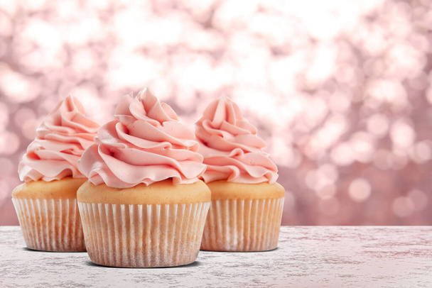 Delicious birthday cupcakes on white table against blurred lights. Space for text - Foto, Imagem
