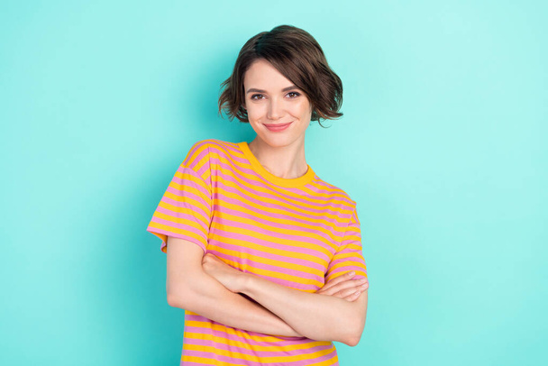 Photo of confident charming young lady wear orange t-shirt arms crossed smiling isolated turquoise color background. - Fotografie, Obrázek