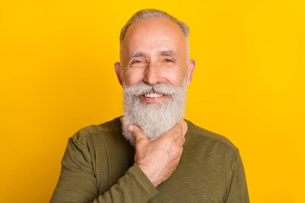 Photo of handsome elderly grandpa touch well-groomed beard wear green shirt isolated yellow color background. - Fotografie, Obrázek