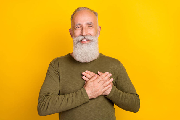 Photo of peaceful sincere grandpa hands heart beaming smile wear green shirt isolated yellow color background. - Photo, Image