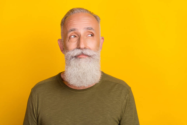 Photo of curious thoughtful pensioner grandpa look empty space wear green shirt isolated yellow color background. - Φωτογραφία, εικόνα
