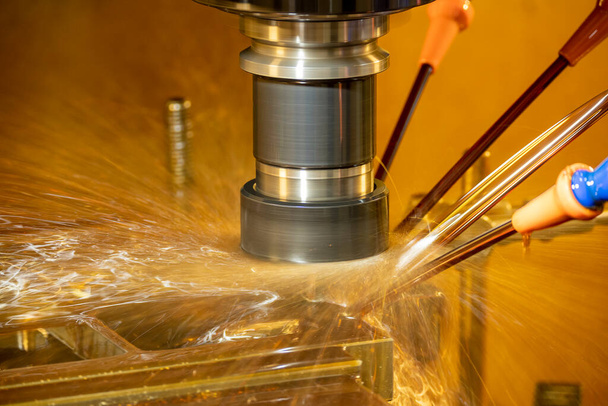 Die CNC-Fräsmaschine schneidet die Werkzeugteile im Ölkühlverfahren. Der Werkzeug- und Formenbau mittels CNC-Bearbeitungszentrum. - Foto, Bild