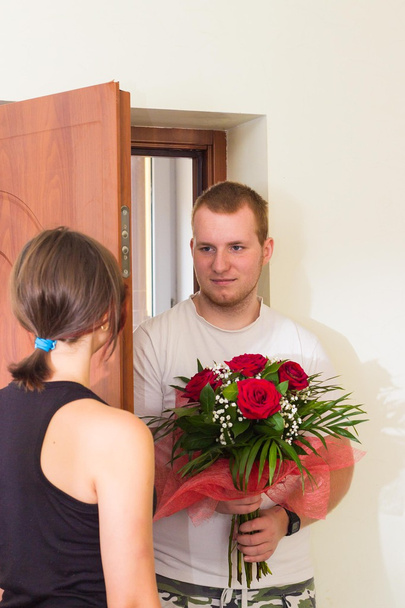 Fille rencontre petit ami avec des fleurs près de la porte
 - Photo, image