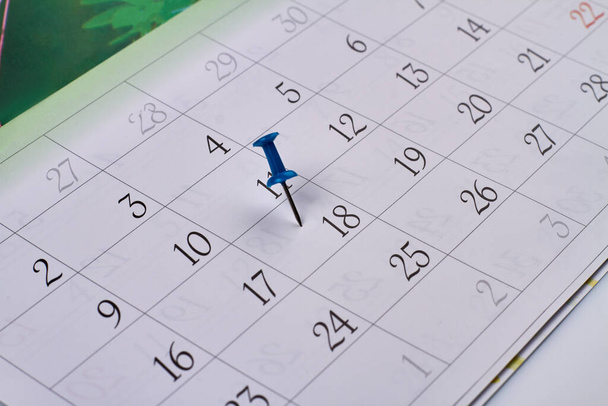 Gros plan broche bleue sur le calendrier du mois. Marquer le 18e jour du mois. - Photo, image