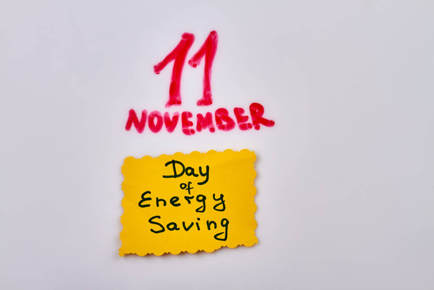 Aufkleber mit Energiesparhandschrift vom 11. November. Isoliert auf weißem Hintergrund. - Foto, Bild