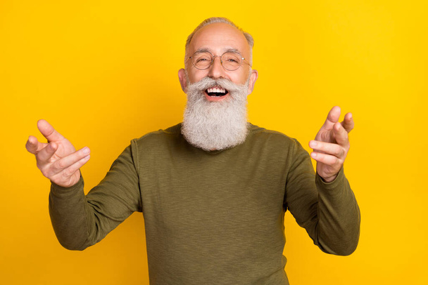 Photo of cool elder grey beard man talk wear eyewear green sweater isolated on yellow color background. - Photo, image