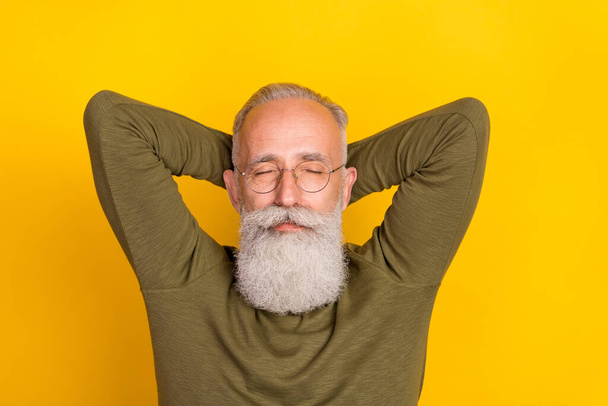 Photo of rest elder grey beard man hands head sleep wear eyewear green sweater isolated on yellow color background. - Fotó, kép