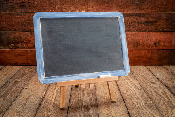 blank slate blackboard easel sign on a rustic weathered wood, retro classroom concept - Photo, Image