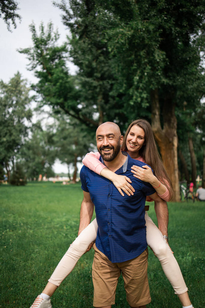 bald man hugs his beloved in meadow, concept of dating, falling in love - Photo, Image