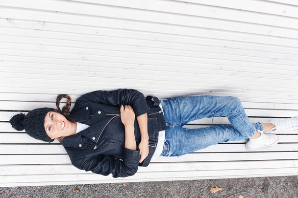 Beautiful young female lying on a park bench - Foto, Imagen