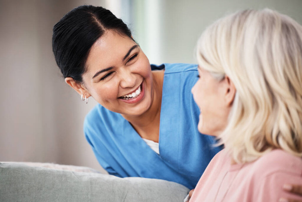 Shot of a female nurse smiling while talking to her patient - Foto, Imagen