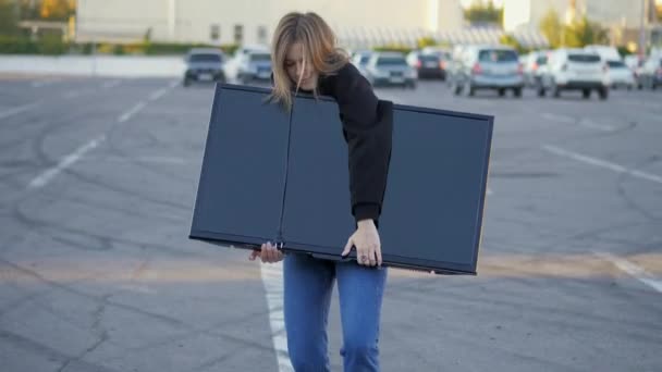 Nainen hauska yrittää laittaa ostettu moderni tv auton takakonttiin myymälässä pysäköinti lähikuva, toimitus käsite - Materiaali, video