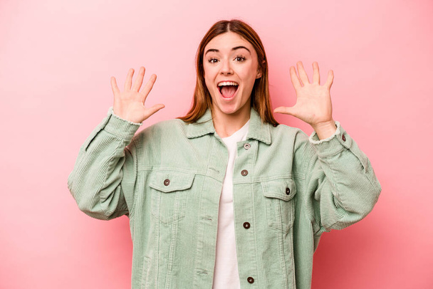 Young caucasian woman isolated on pink background receiving a pleasant surprise, excited and raising hands. - Φωτογραφία, εικόνα