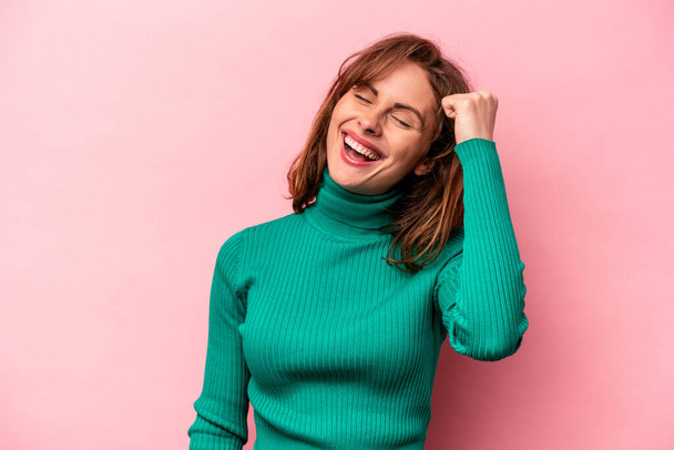 Young caucasian woman isolated on pink background celebrating a victory, passion and enthusiasm, happy expression. - Photo, Image