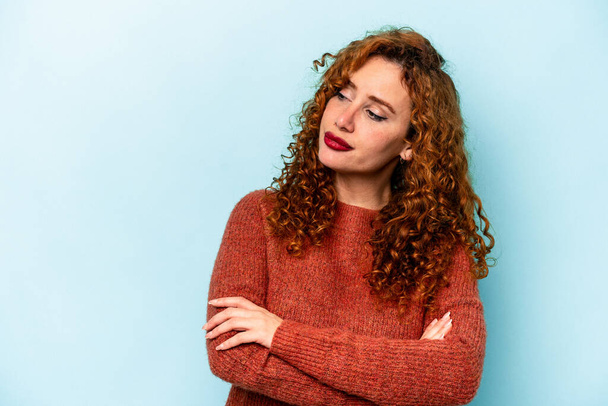 Young ginger caucasian woman isolated on blue background dreaming of achieving goals and purposes - Foto, afbeelding