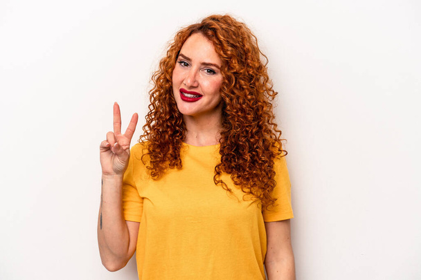 Junge Ingwer kaukasische Frau isoliert auf weißem Hintergrund fröhlich und unbeschwert zeigt ein Friedenssymbol mit Fingern. - Foto, Bild