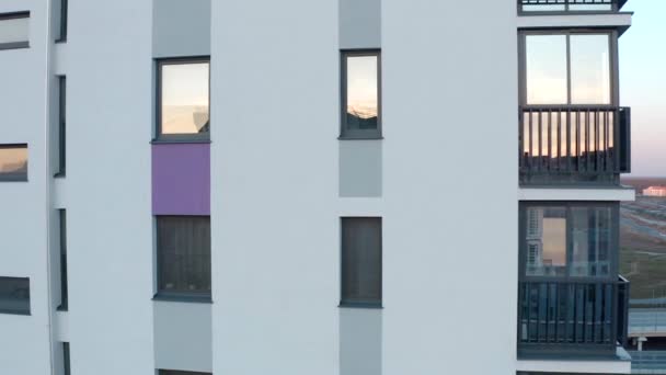 Pencereli modern konut binasının üst manzarası. Stok görüntüleri. Pencereli konutların dikey panelleri. Konut binasının pencerelerinde gökyüzünün yansıması.  - Video, Çekim