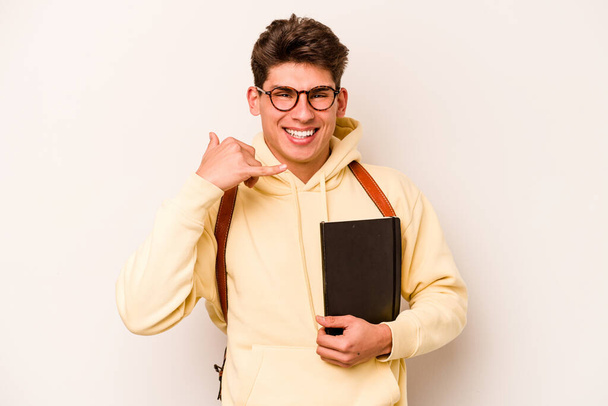 Νεαρός μαθητής καυκάσιος άνδρας απομονωμένος σε λευκό φόντο που δείχνει χειρονομία κινητής τηλεφωνίας με δάχτυλα. - Φωτογραφία, εικόνα
