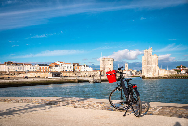 La Rochelle old harbor. Rear view of a bicycle looking at city view while standing on observation point. - Photo, Image